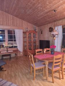 a dining room with a table and chairs and a television at Idyllic house on a farm in Steinkjer