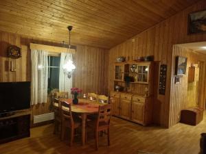 a dining room with a table and chairs and a television at Idyllic house on a farm in Steinkjer +6 photos
