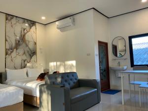 a bedroom with a bed and a chair and a sink at Lanta Beautiful beach house 1 in Phra Ae beach +29 photos