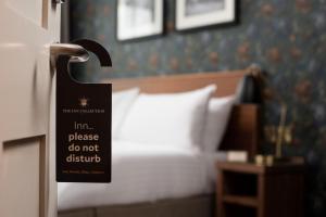 a hotel room with a bed with a sign on the door at The Wordsworth, Grasmere - The Inn Collection Group in Grasmere