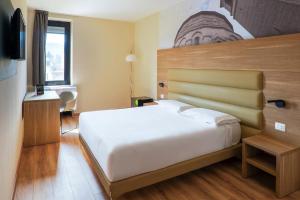 a bedroom with a large white bed in a room at B&B HOTEL Fabriano Janus in Fabriano