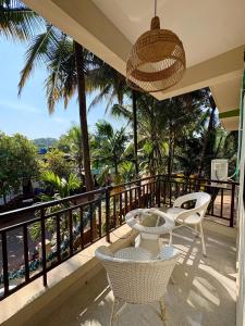 a balcony with chairs and a view of the ocean at The Habitat By Locomo in Mandrem