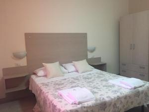 a bedroom with a bed with pink towels on it at Belvedere Residence in Zungri