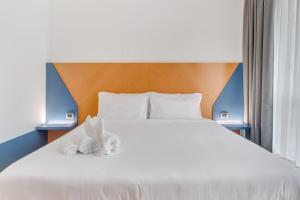 a bedroom with a bed with towels on it at B&B HOTEL Bergamo Executive in San Paolo D'Argon