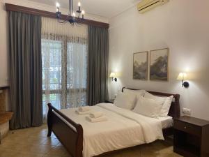 a bedroom with a bed with two towels on it at Ξενώνας Ρόδον in Kato Loutraki