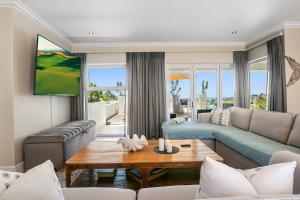a living room with a couch and a table at SL9 - Pezula Double Storey Luxury in Knysna