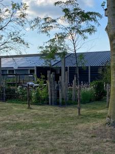a building with a fence in front of a yard at Slapen bij Uppruna in Chaam