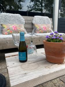 a bottle of wine sitting on a table next to a plant at Slapen bij Uppruna in Chaam +36 photos