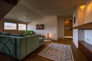 a living room with a green couch and a fireplace at Apartments Salim in Sarajevo