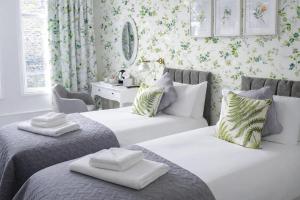 a bedroom with two beds and a desk with a mirror at The Milford Arms in Hounslow