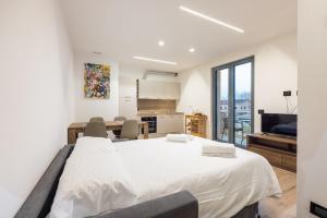 a bedroom with a large white bed and a kitchen at La Strencia in Villa di Tirano
