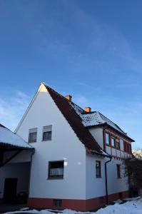 a white house with snow on the roof at Ferienwohnung Landleben in Bühlertann