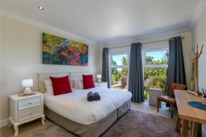 a bedroom with a large bed with red pillows at SL9 - Pezula Double Storey Luxury in Knysna +65 photos