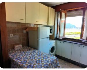 a kitchen with a refrigerator and a washer and dryer at Apartamento El Muro in Laredo