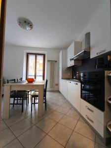 a kitchen with a table and a dining room at In Centro in Domodossola