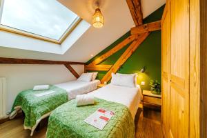two beds in a room with green walls at Hideout in Morzine