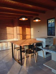 a kitchen with a wooden table and chairs at Complejo DOS LUNAS in San Roque +2 photos