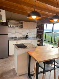 a kitchen with a wooden table and a counter top at Complejo DOS LUNAS in San Roque