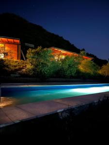 a swimming pool in front of a building at night at Complejo DOS LUNAS in San Roque