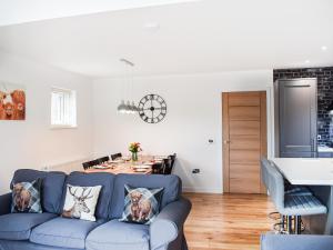 a living room with a blue couch and a table at Rubys Cottage in Crieff