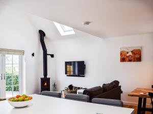 a living room with a couch and a stove at Rubys Cottage in Crieff