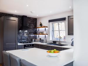 a kitchen with a bowl of fruit on a counter at Rubys Cottage in Crieff
