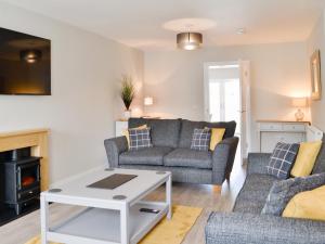a living room with a couch and a table at Crofthouse - Uk43405 in Wigtown