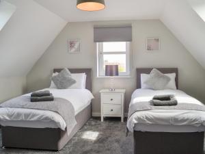 a bedroom with two beds and a window at Crofthouse - Uk43405 in Wigtown +8 photos