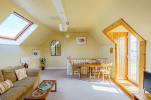 a living room with a couch and a table at The Cheeseloft - Spacious one bed with terrace in Kirkcudbright