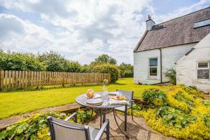 a patio with a table and chairs in a yard at The Cheeseloft - Spacious one bed with terrace in Kirkcudbright