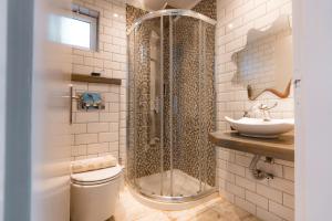 a bathroom with a shower and a toilet and a sink at Rizos Bay Sarakiniko in Sarakiniko +14 photos