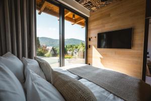 a bedroom with a large window and a tv on the wall at Niebo Beskidu in Brenna