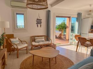 a living room with chairs and a table at Le Mazet au Lavandou in Le Lavandou