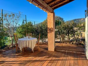 a table and chairs on a wooden deck at Le Mazet au Lavandou in Le Lavandou