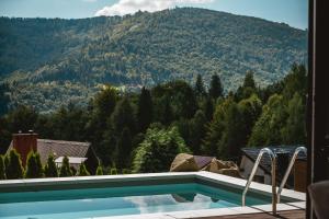 a swimming pool with a view of a mountain at Niebo Beskidu in Brenna
