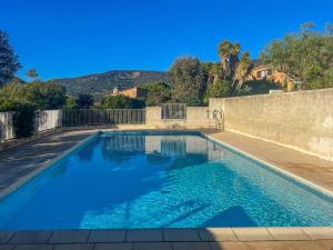 a swimming pool with blue water in front of a wall at Le Mazet au Lavandou in Le Lavandou