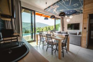 a kitchen and living room with a table and chairs at Niebo Beskidu in Brenna