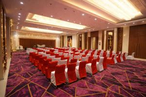 a conference room with red chairs and a stage at Green Mountain Resort in Guna +59 photos