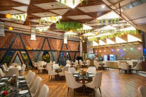 a dining room with tables and white chairs at Green Mountain Resort in Guna