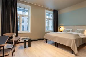 a hotel room with a bed and a table and chairs at Comfort Hotel Park in Trondheim