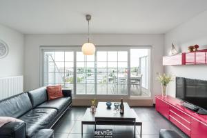 a living room with a couch and a tv at Maison Beluga - spacious apartment in Westende in Middelkerke