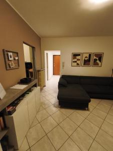 a living room with a black couch and a tile floor at In Centro in Domodossola