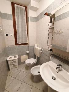a bathroom with a toilet and a sink at In Centro in Domodossola +36 photos