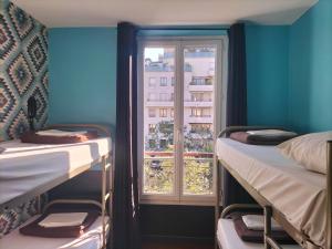 a room with two bunk beds and a window at Oops! Latin quarter by Hiphophostels in Paris