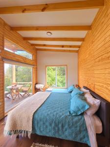 a bedroom with a bed and a large window at Casa Río de Mozzi in Castro