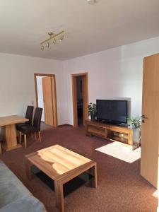 a living room with a television and a table at Apartment - Gästewohnung - Unterkunft Monteure in Chemnitz