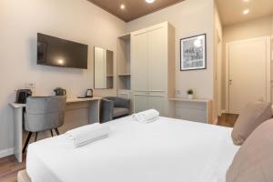 a bedroom with a white bed and a desk and a computer at Welcome Foresteria Lombarda in Milan