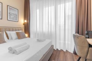 a bedroom with a white bed with a chair and a window at Welcome Foresteria Lombarda in Milan