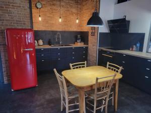 a kitchen with a wooden table and a red refrigerator at Le Loft Des Arts in Thonon-les-Bains