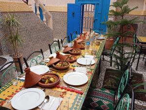 a long table with plates of food on it at Riad Ingbiwn N'Tiznit in Tiznit